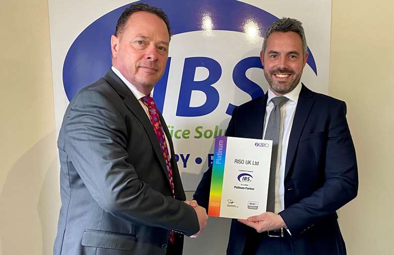 Southwell (left) receiving his award from Riso UK head of sales Russell Long